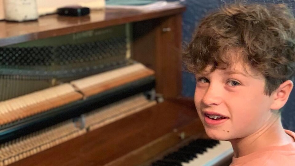 Le jeune homme joue du piano.