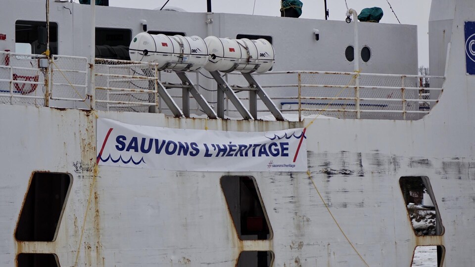 Une banderole sur le bateau où il est écrit : Sauvons l'Héritage.