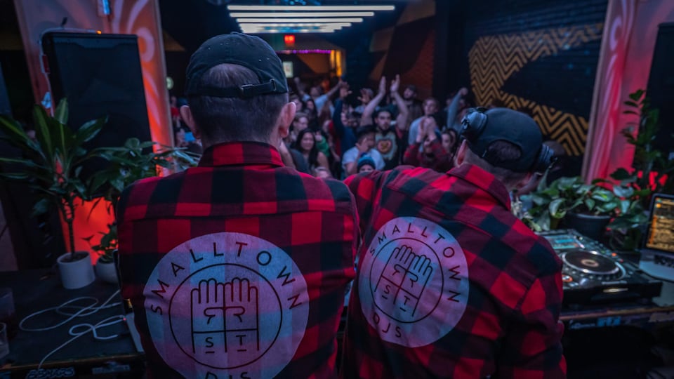 Des DJ jouent devant une foule dans le HiFi Club, à Calgary.