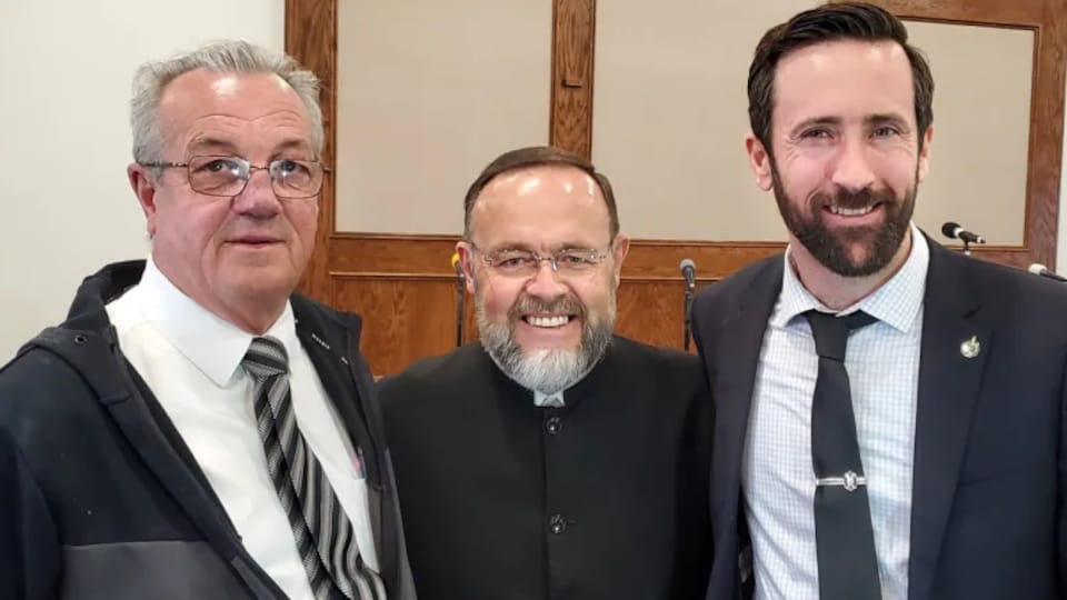 Le député Randy Hillier, à gauche, et le député Derek Sloan flanquent le pasteur de l’église Church of God Restoration, Henry Hildebrandt.
