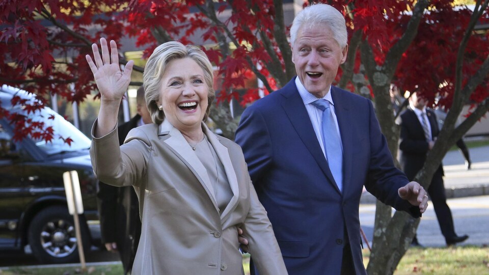 Hillary et Bill Clinton saluent le public à leur arrivée à un événement.