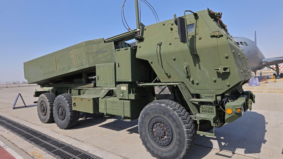 A HIMARS rocket vehicle on an airport tarmac.