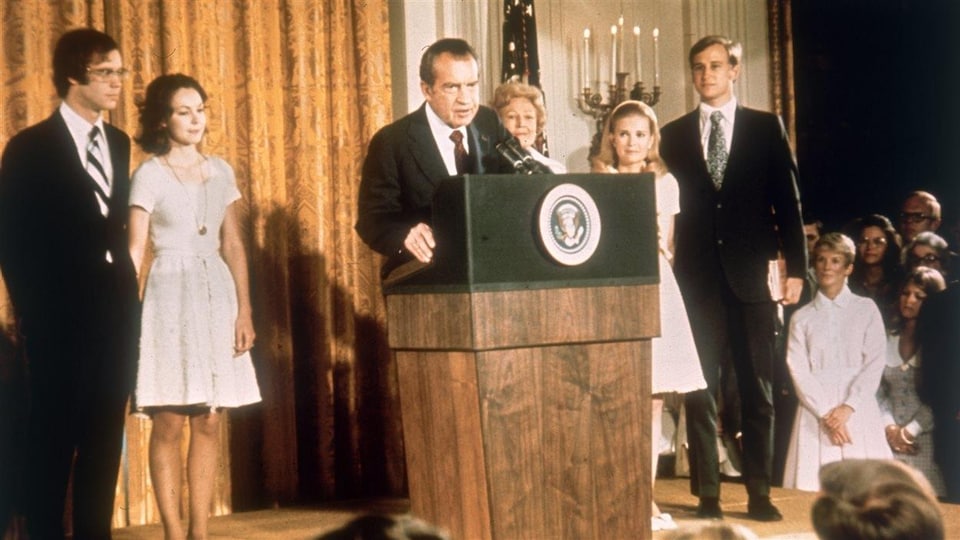 Richard Nixon en compagnie de membres de sa famille, debout derrière un lutrin, lors de son discours de démission le 9 août 1974