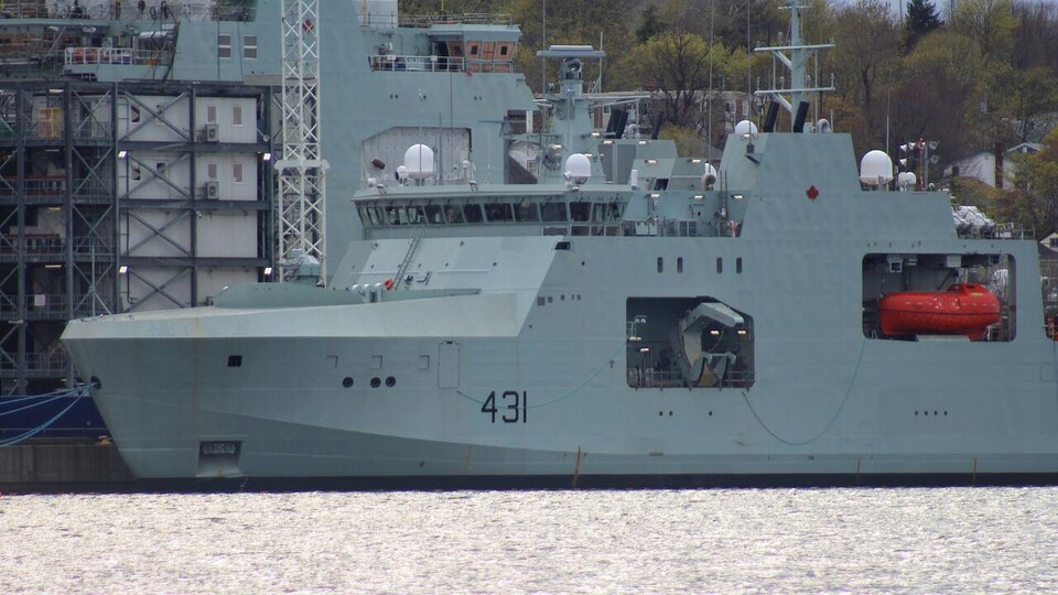 Un navire militaire amarré à un quai.