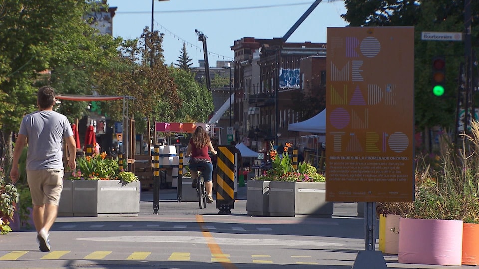 Un piéton et une cycliste sur la promenade Ontario.