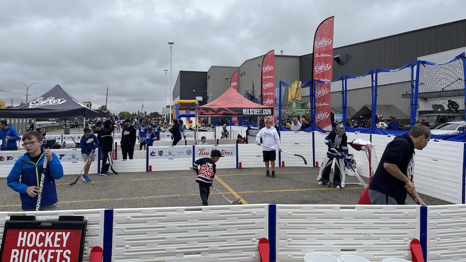 Des jeunes jouent au hockey dans une aréna sur rue, au Jets Fan Fest, le 24 septembre 2022. 