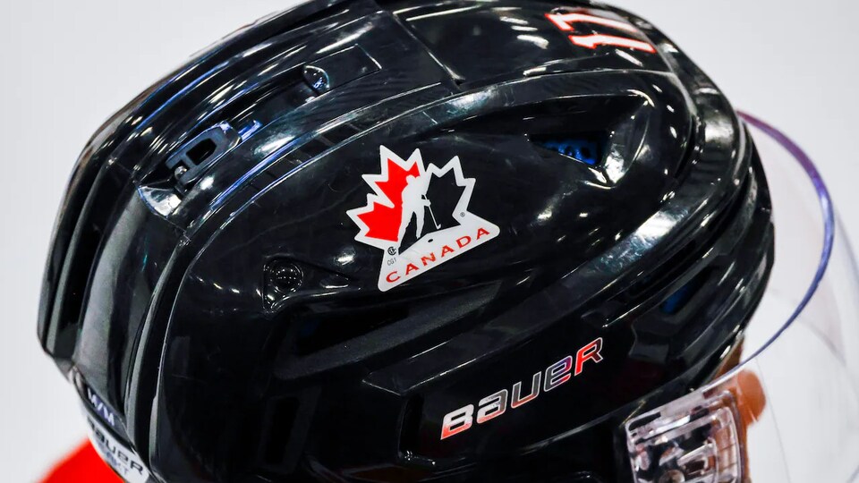 Gros plan sur un casque de hockey noir, avec le logo de Hockey Canada.
