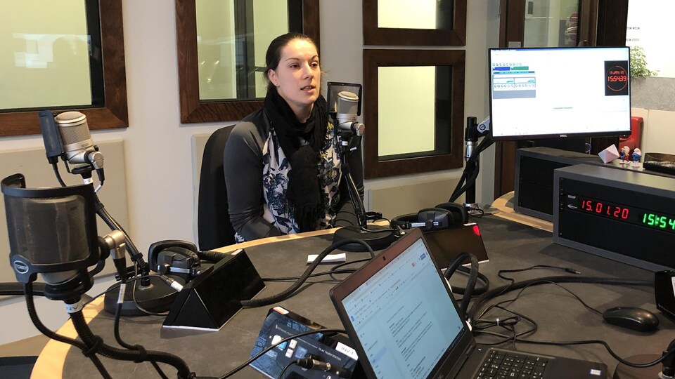 Annie Guay parle au micro dans le studio de radio.