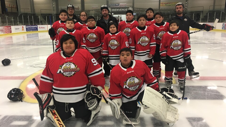 Les joueurs de l'équipe posent pour une photo de groupe sur la glace du Foyer des loisirs.