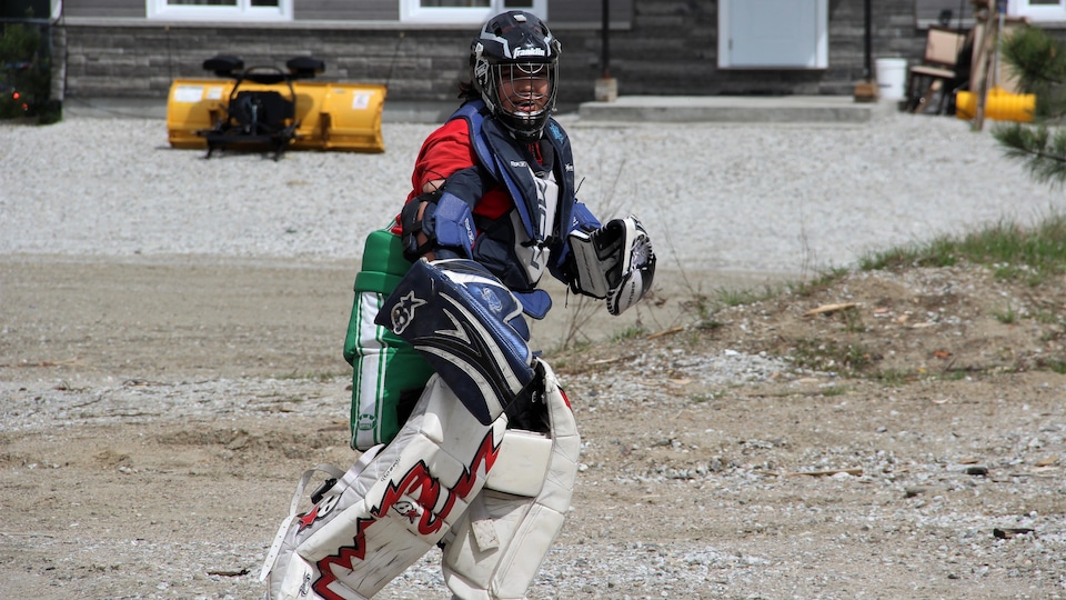 A youngster who has donned hockey goalkeeper equipment.