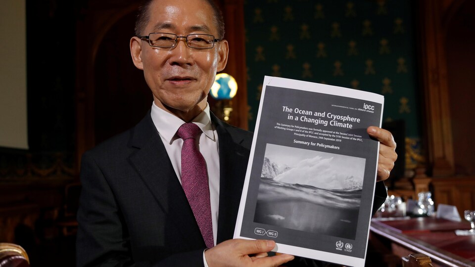 Le président du GIEC, Hoesung Lee, pose avec une copie du rapport spécial sur les océans et la cryosphère.