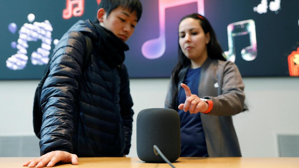 Deux personnes discutent devant un assistant vocal.