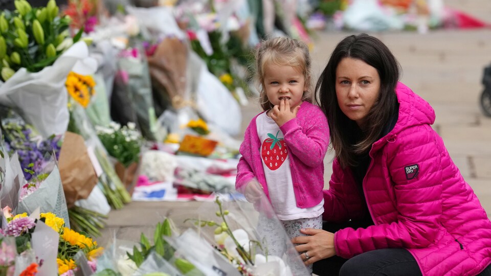 Une femme et son enfant devant le palais de Buckingham.