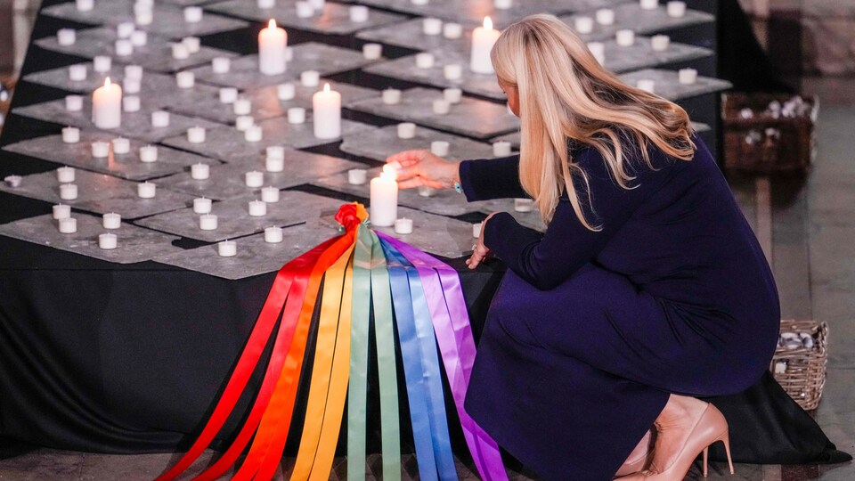 Une femme allume des bougies dans la cathédrale d'Oslo.