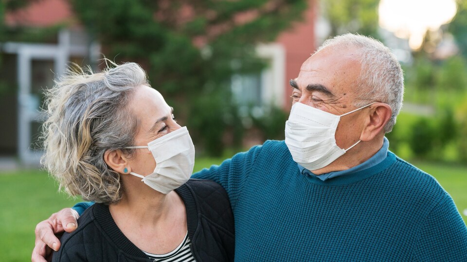 Un homme et une femme portent des masques.