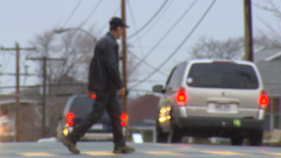 Un homme marche sur la rue.