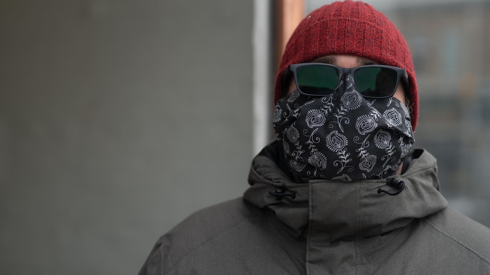 Un homme porte masque et tuque.