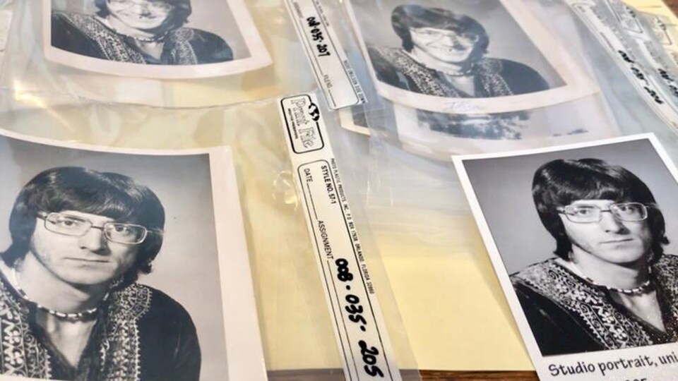 Plusieurs copies d'une photo d'un homme, en noir et blanc. L'homme a des cheveux foncés, de grosses lunettes, un collier et semble être un adepte du mouvement hippy.