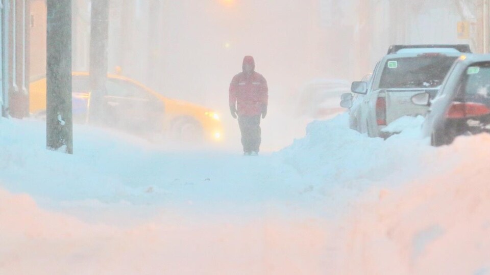 Un homme marche en pleine tempête à Québec
