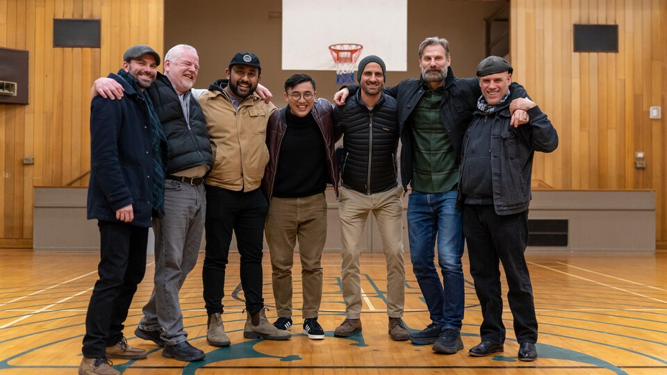 Des hommes souriants se rassemblent lors d'une rencontre de soutien.