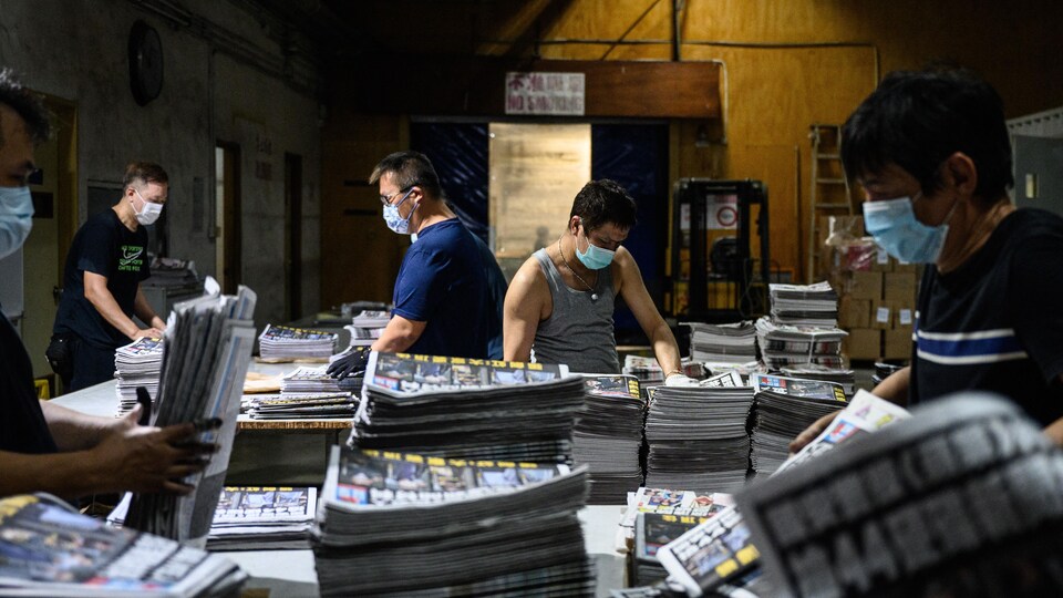 Des employés hongkongais travaillent à la parution d'un journal.