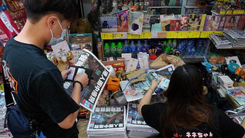  Un client à un kiosque à journaux de Hong Kong.
