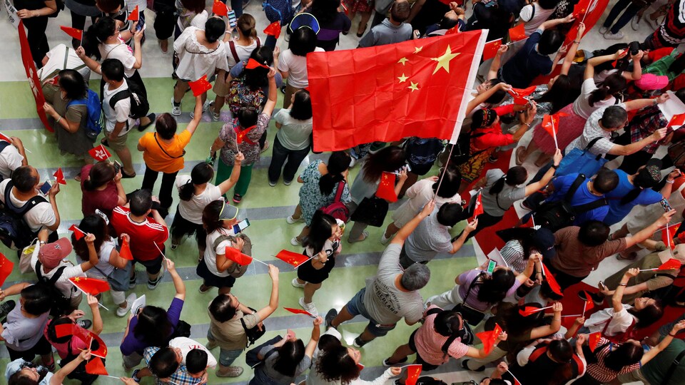Une foule vue de haut agite des drapeaux chinois