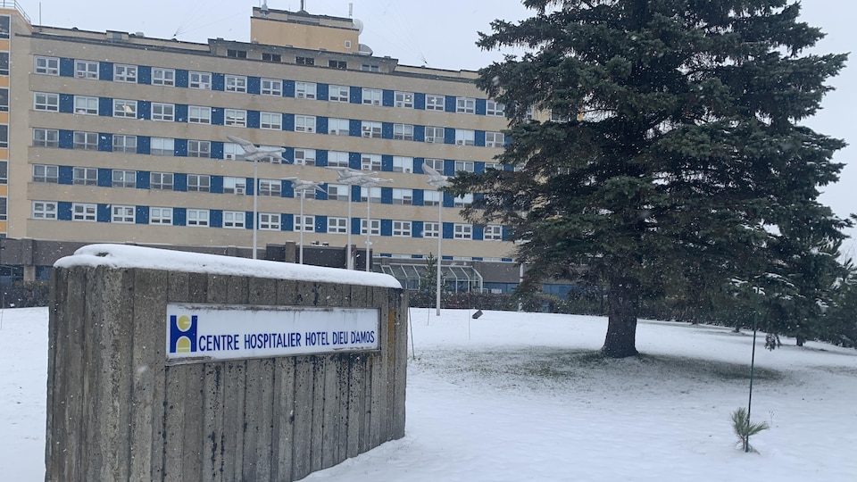 La neige recouvre la pelouse devant l'hôpital.