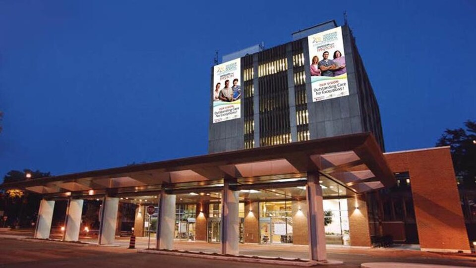 La facade du bâtiment est illuminée, et on peut y voir deux grandes affiches blanches.