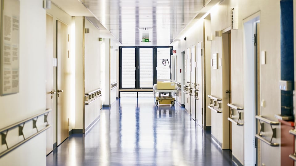 Un lit dans le corridor vide d'un hôpital.