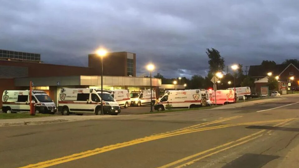 Au moins sept ambulances sont garées devant une entrée.