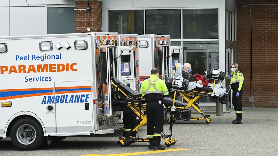 Des ambulanciers devant l'entrée de l'urgence.