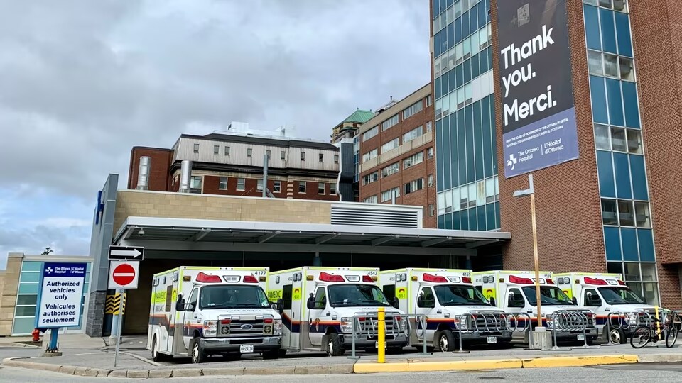 Cinq ambulances stationnées devant l'Hôpital d'Ottawa. 