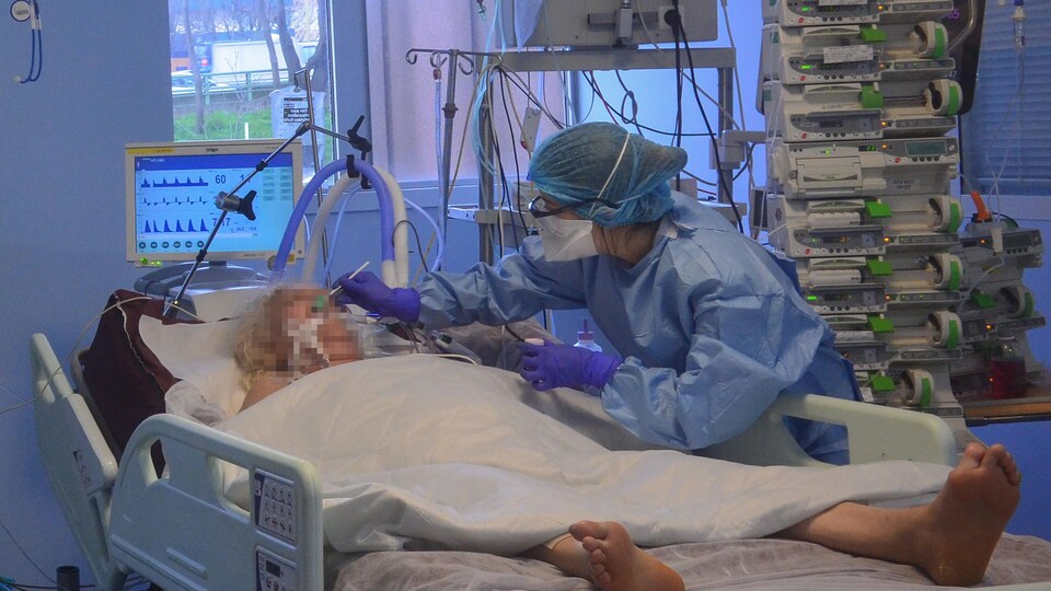 Une infirmière soigne une femme dans un hôpital français.