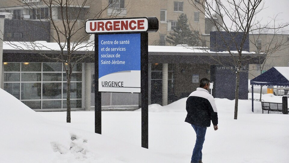 Un homme marche devant l'hôpital de Saint-Jérôme