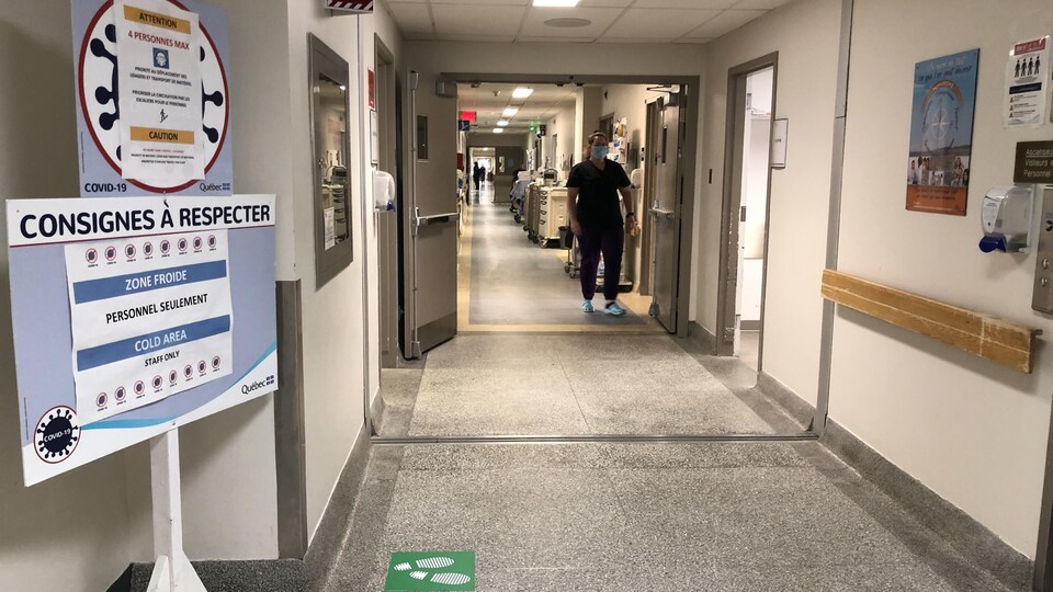 Un corridor de l'hôpital de Sept-Îles. Un employé est debout dans le corridor.