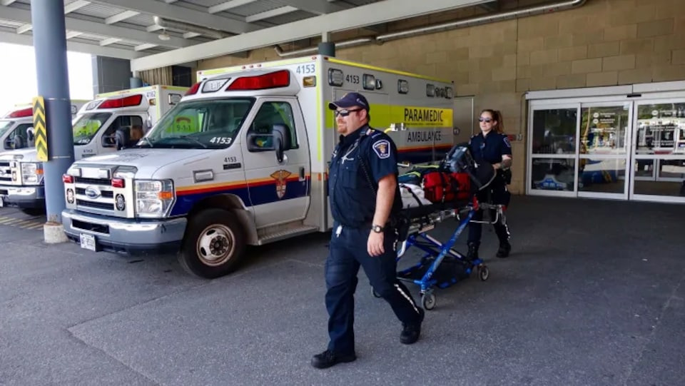 Des ambulanciers paramédicaux à la sortie d'un hôpital d'Ottawa.