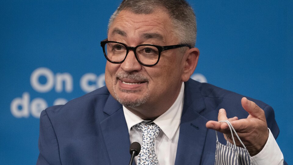 Le directeur de la Santé publique du Québec, Horacio Arruda, tient un masque dans sa main gauche.