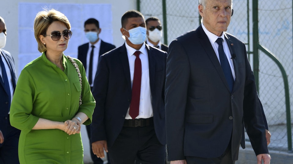 Le président tunisien Kaïs Saïed (à droite) arrive avec sa femme pour voter.