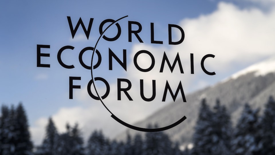 Le logo du Forum économique mondial sur une vitrine près des Alpes suisses.