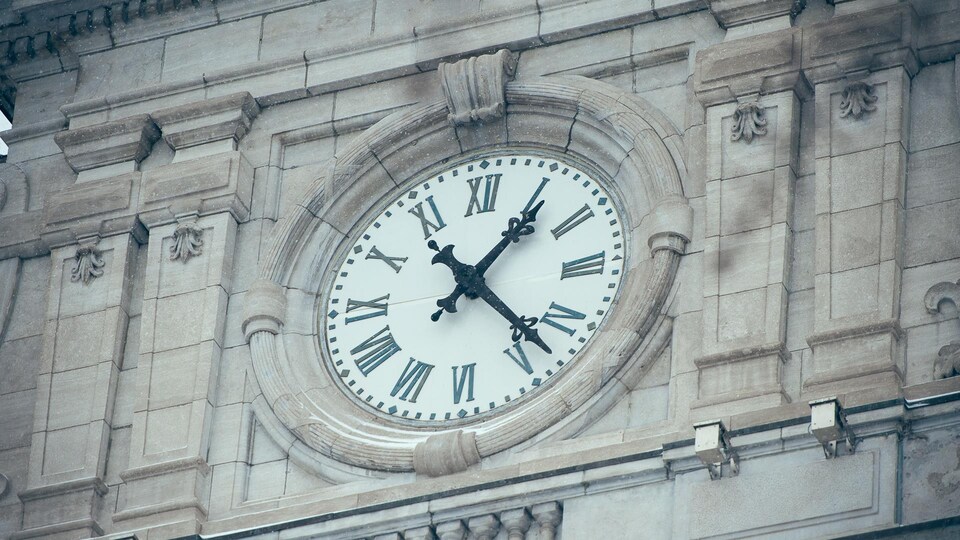 Zoom sur l'horloge de l'Hôtel de ville de Montréal qui indique 13 h 20 par une froide journée d'hiver.