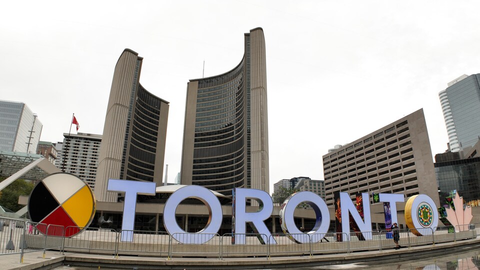 Les lettres géantes de Toronto avec l'hôtel de ville en arrière-plan.