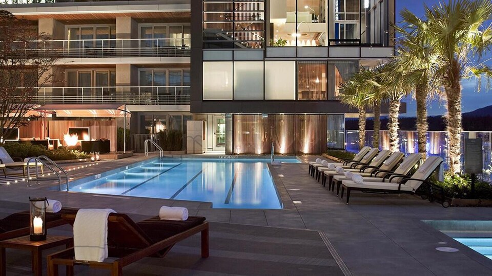 Des transats autour d'une piscine d'un hôtel de luxe.