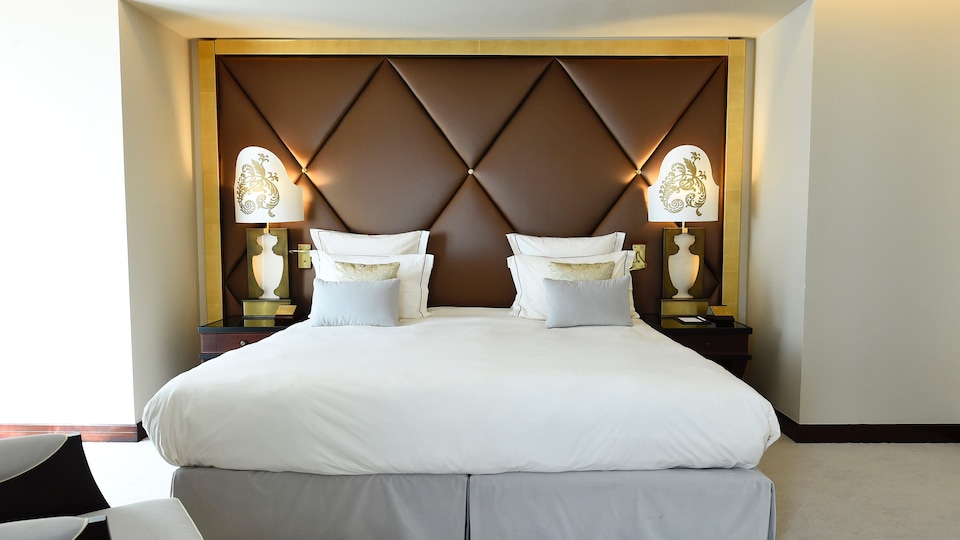 Une chambre d'hôtel comprenant un lit encadré par deux lampes.
