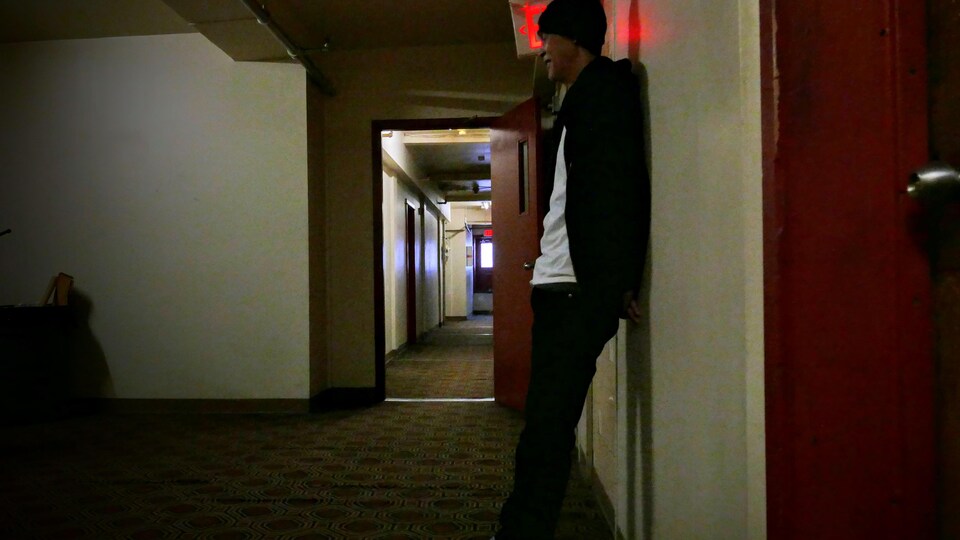 Jimmy est adossé au mur d'un des couloirs de l'hôtel. 