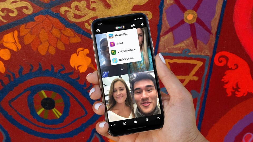 Une personne tient un téléphone intelligent dans sa main et est en conversation vidéo avec ses proches.