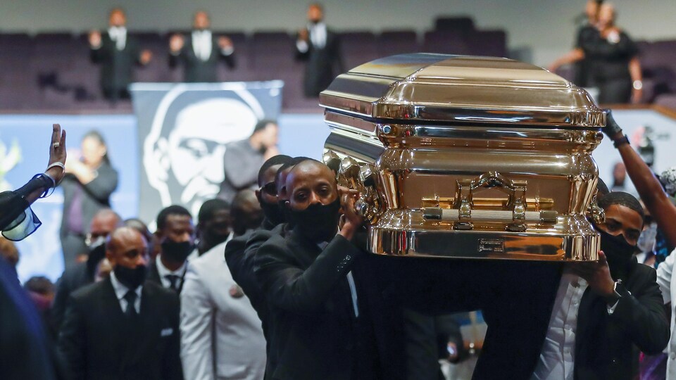 Des hommes noirs transportent sur leurs épaules le cercueil de George Floyd en sortant de l'église.