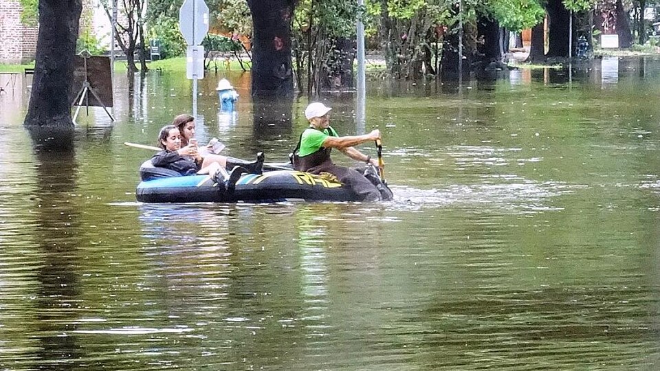 Des sinistrés naviguent dans les rues de Houston à bord d'une petite embarcation gonflable.