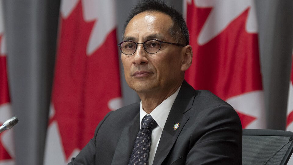 L'administrateur en chef adjoint à l'Agence de la santé publique du Canada est assis derrière une table, lors d'une conférence de presse.

