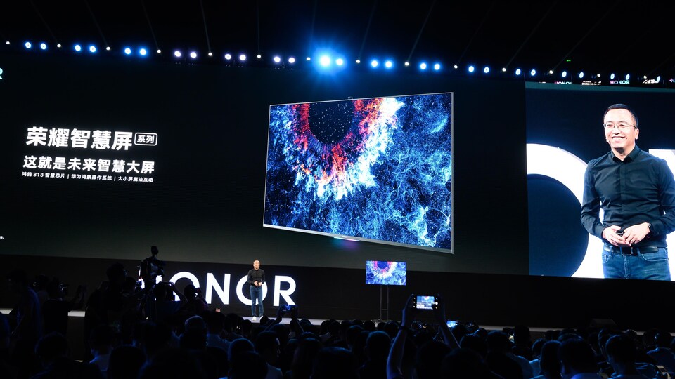 George Zhao dévoile la première télévision intelligente de l'entreprise, sur scène, devant une foule réunie lors d'une conférence à Dongguan, en Chine.